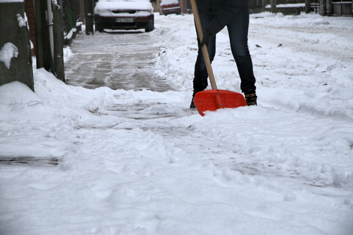odśnieżanie szuflą, dozorca sprząta śnieg - Archiwum