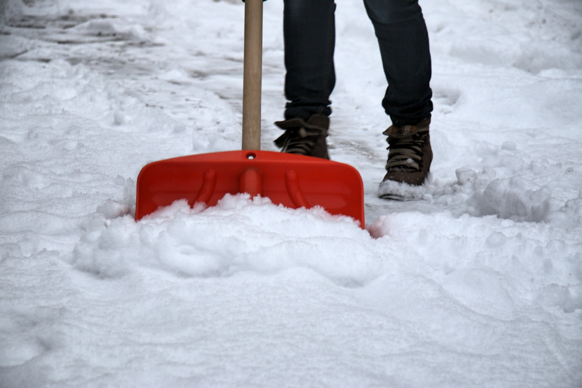 odśnieżanie szuflą, dozorca sprząta śnieg - Archiwum