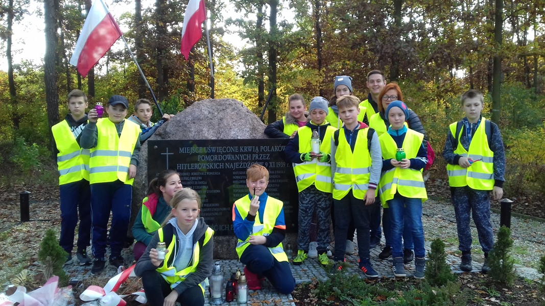 Uczniowie Szkoły Podstawowej im. Jana Pawła II podczas rajdu rowerowego zapalili znicze przed obeliskiem upamiętniającym ofiary Ziemi Kościańskiej w Lesie w Kurzej Górze koło Kościana oraz na rynku w Kościanie.