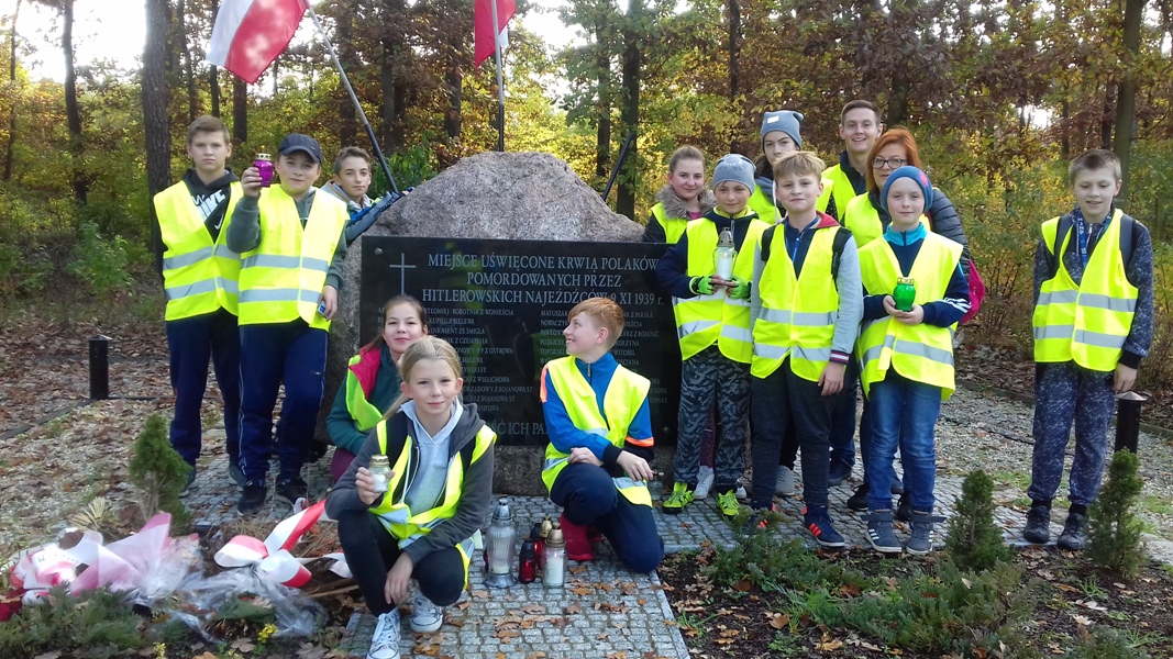 Uczniowie Szkoły Podstawowej im. Jana Pawła II podczas rajdu rowerowego zapalili znicze przed obeliskiem upamiętniającym ofiary Ziemi Kościańskiej w Lesie w Kurzej Górze koło Kościana oraz na rynku w Kościanie.