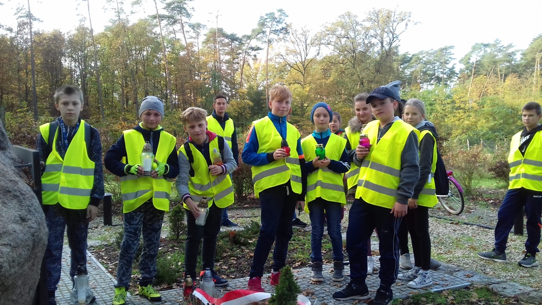 Uczniowie Szkoły Podstawowej im. Jana Pawła II podczas rajdu rowerowego zapalili znicze przed obeliskiem upamiętniającym ofiary Ziemi Kościańskiej w Lesie w Kurzej Górze koło Kościana oraz na rynku w Kościanie.