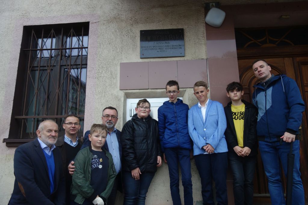 Pod tablicą upamiętniającą zamęczonego  w 1939 roku działacza społecznego Wojciecha Bąka, uczniowie SP 1 i 2