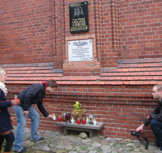 Znicz Pamięci - grupa polskich i niemieckich studentów przy tablicy pamiątkowej w szpitalu psychiatrycznym Dziekanka w Gnieźnie/fot.R.Muniak