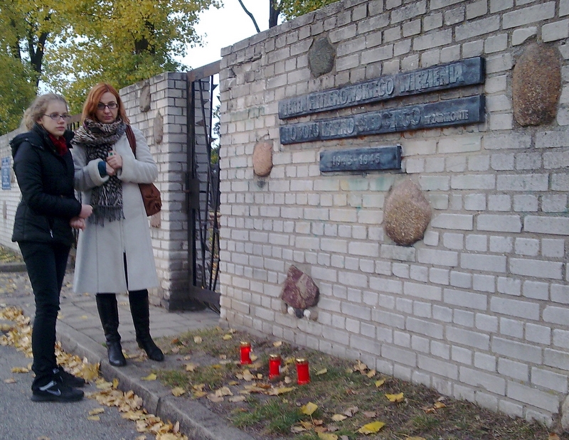 Znicze pod murem Muzeum Martyrologii w Żabikowie