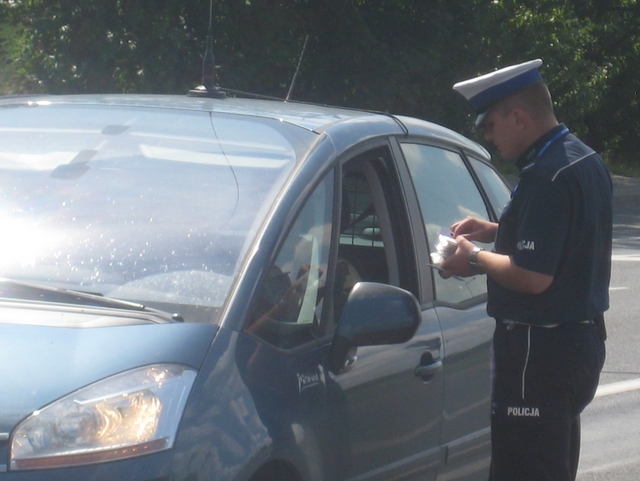 Policjant rozdaje ulotki - mycie szyb - Wojciech Chmielewski