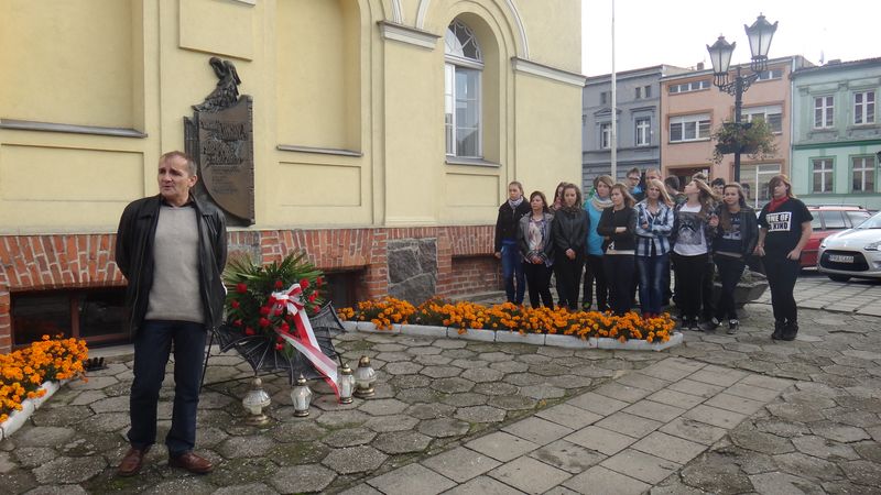 Uczniowie SP i Gimnazjum w Poniecu zapalili znicze pod tablicą na ścianie Ratusza