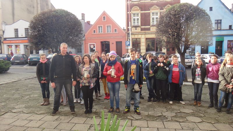 Uczniowie SP i Gimnazjum w Poniecu zapalili znicze pod tablicą na ścianie Ratusza