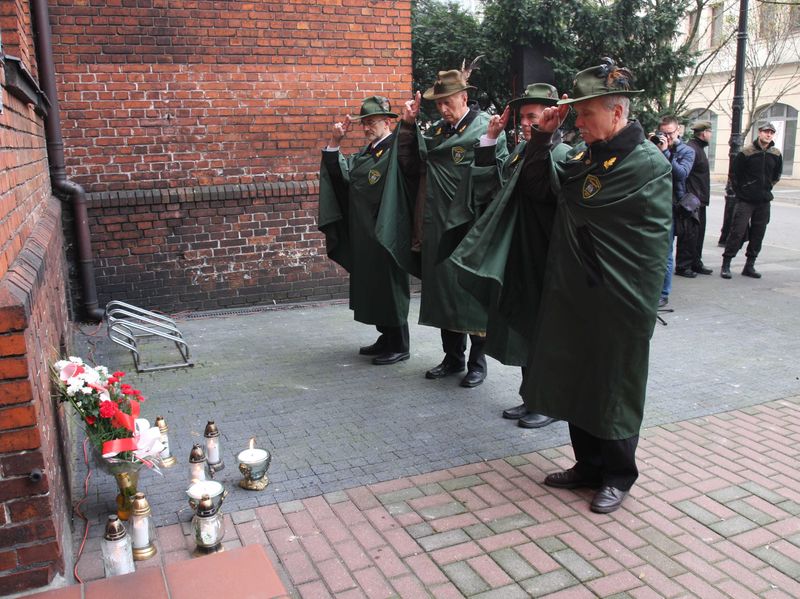 Znicze pod ścianą więzienia we Wrześni
