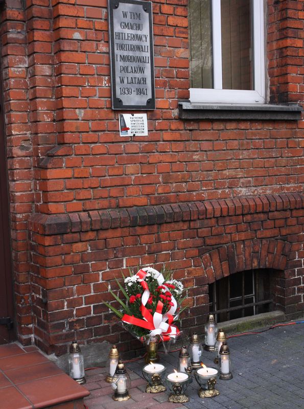 Znicze pod ścianą więzienia we Wrześni