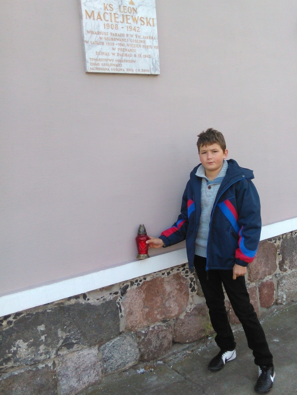 Uczniowie SP nr 1 z Murowanej Gośliny pod tablicą ku czci ks. Leona Maciejewskiego,